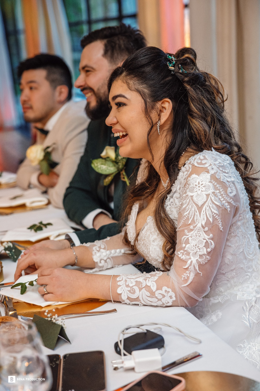 Andréa rit, heureuse et rayonnante dans sa robe de mariée. A son annulaire gauche brille sa nouvelle alliance. Ses cheveux bruns courent librement sur ses épaules. Elle respire le bonheur